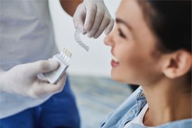 A dentist showing an Invisalign aligner to a patient