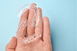 A closeup of mail-in aligners held in a hand
