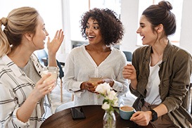 Group of smiling friends hanging out at coffee shop