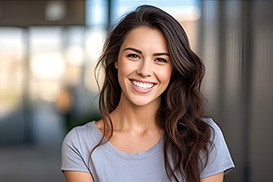 Closeup of woman in grey shirt smiling outside