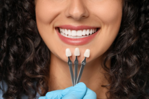 Close up of dentist comparing veneers to patient’s smile