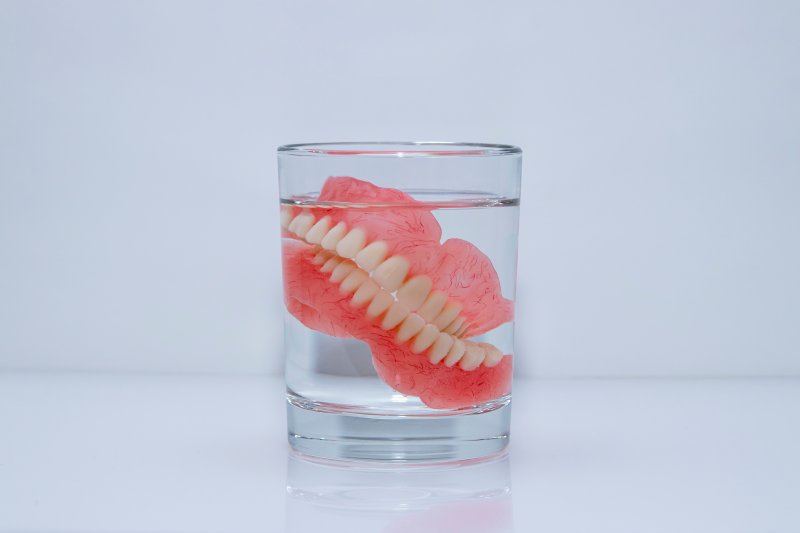 Dentures soak in glass of liquid